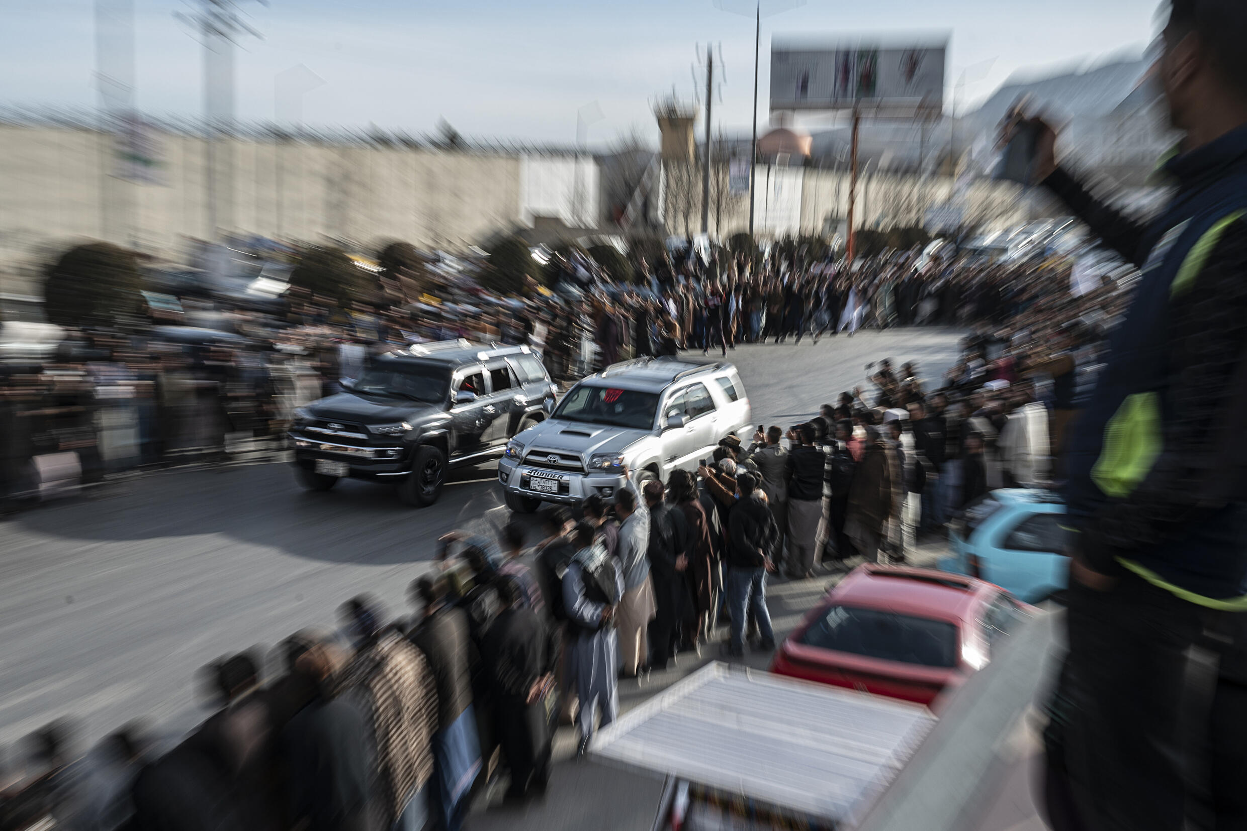 Penonton menyaksikan mobil-mobil yang dimodifikasi berkompetisi dalam perlombaan drag di sepanjang jalan selama acara balap mobil di Kabul.