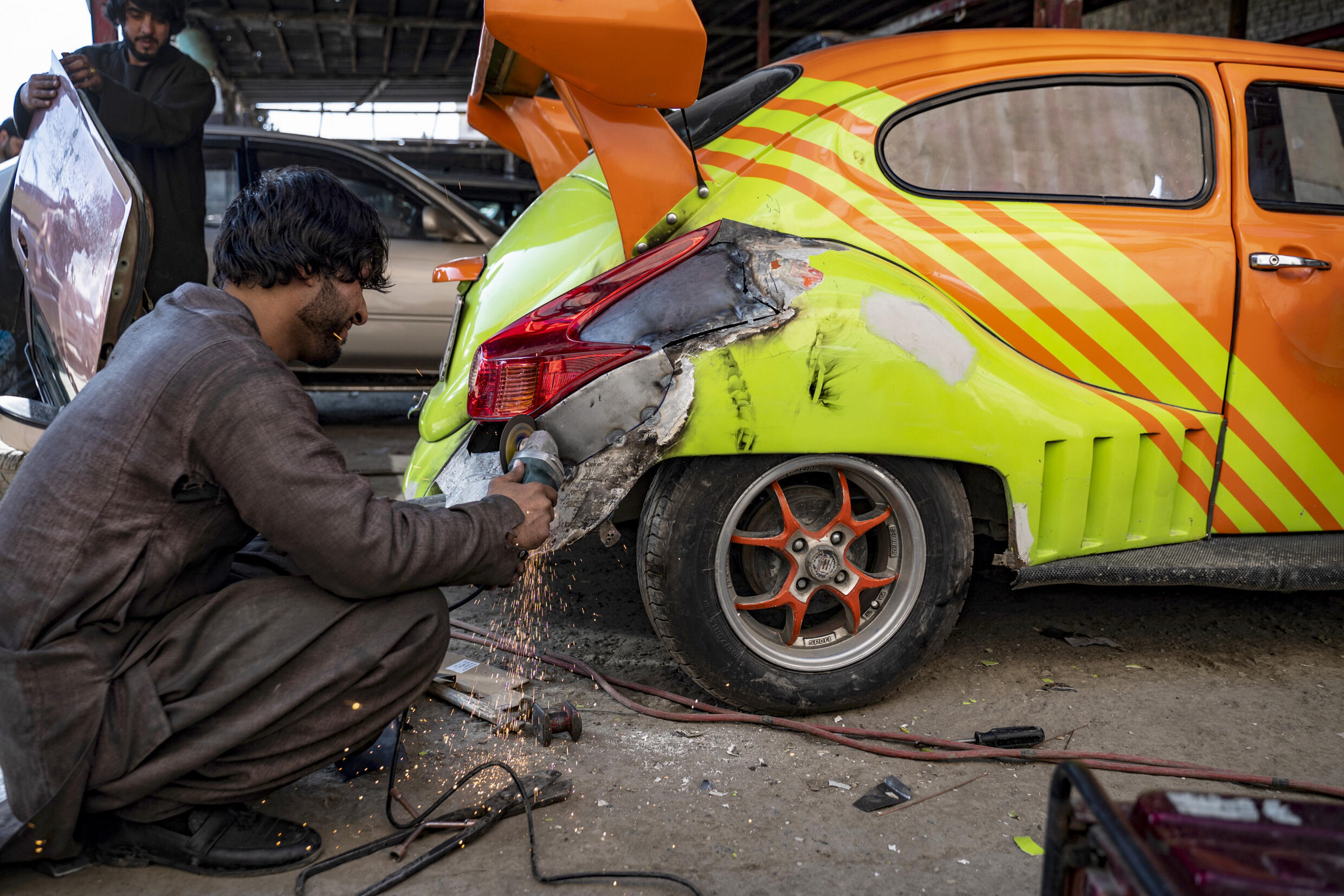 Seorang mekanik Afghanistan mengerjakan mobil yang dimodifikasi di bengkel khusus di Kabul.