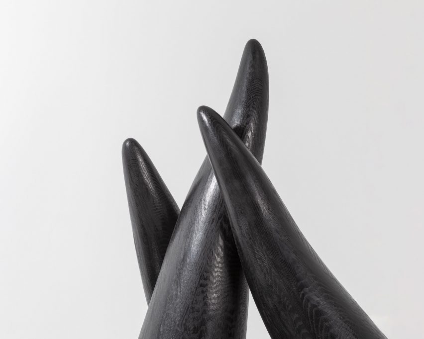 Tampilan dekat dari ujung patung hitam ramping yang berbentuk tentakel.